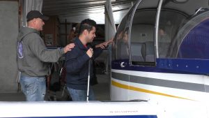 un jeune du centre Lestrade guidé dans sa découverte tactile du corps de l'avion