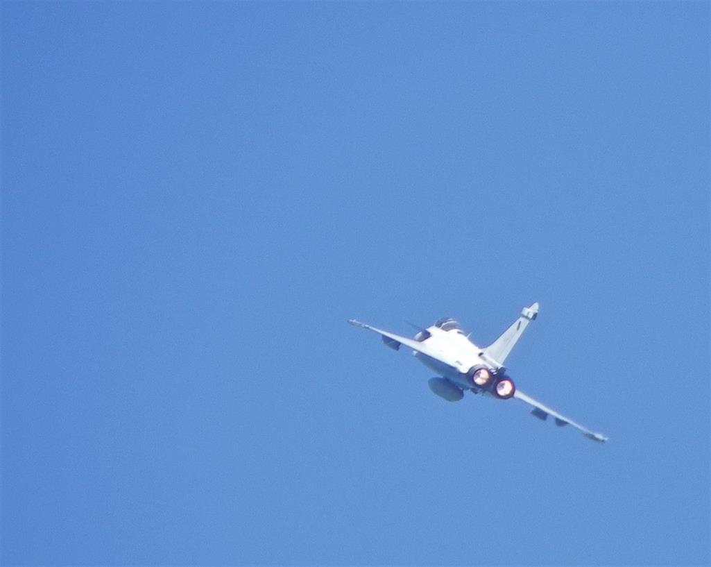 Un passage de rafale de dos: un avion visible sur un ciel entièrement bleu ; le petit flou d'ensemble de l'image atteste de la vitesse de l'avion qui semble filer vers le fond de l'image.