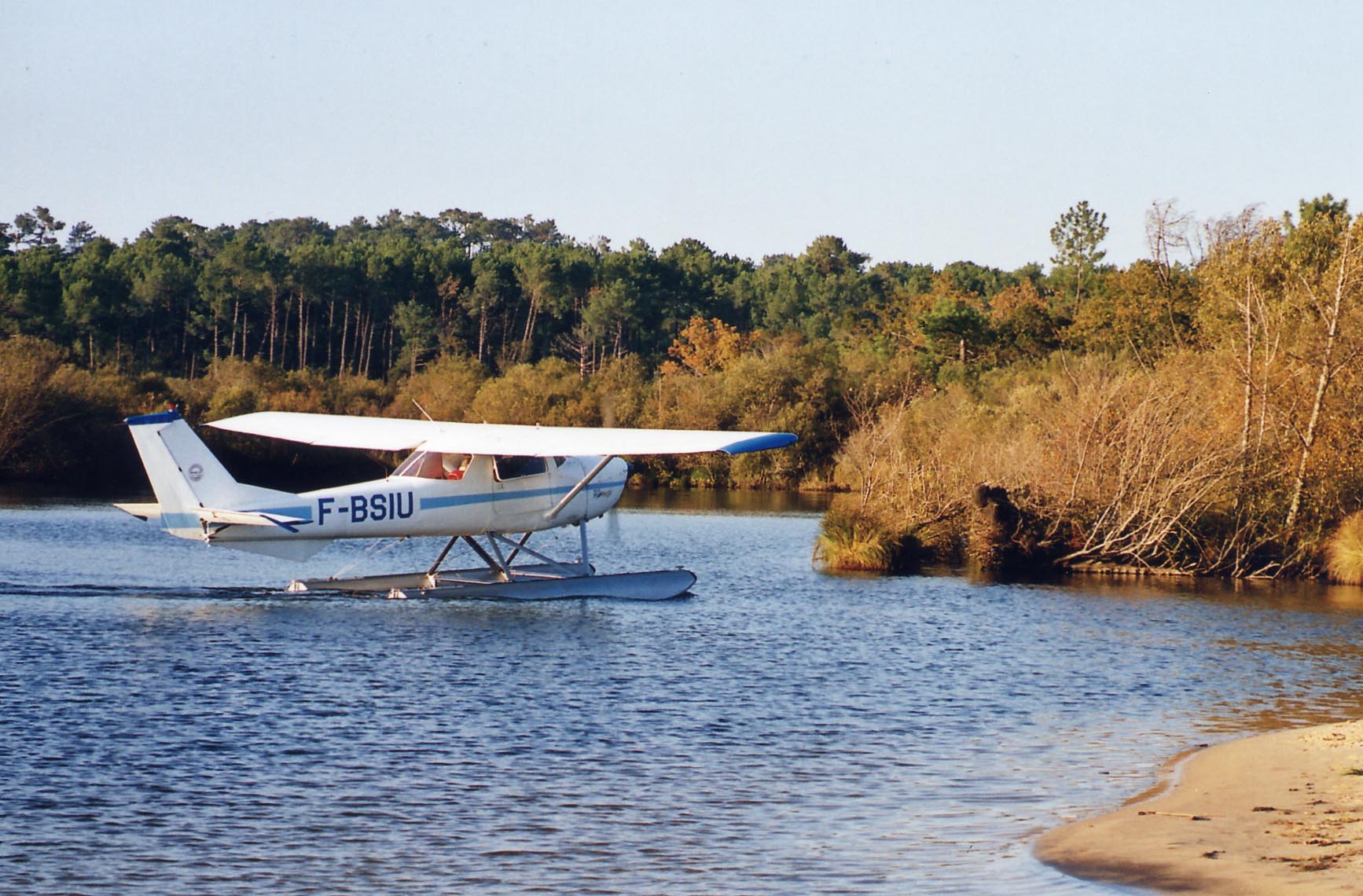 F-BSIU sur le lac de Biscarrosse en 2004, proches des rives bordées d'arbres en forêts