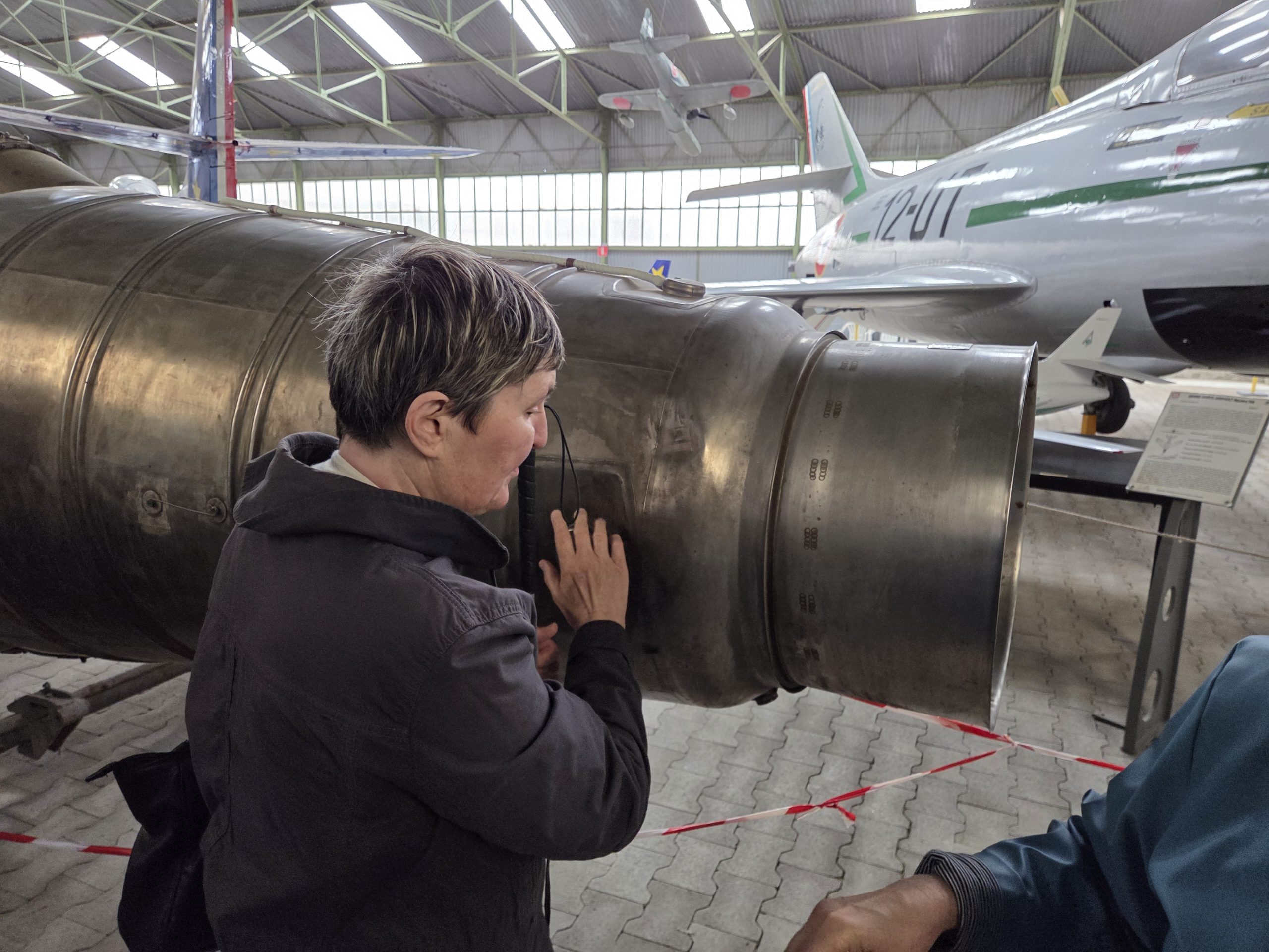 Une de nos adhérentes en train de toucher un élément d'avion à l'intérieur du musée.