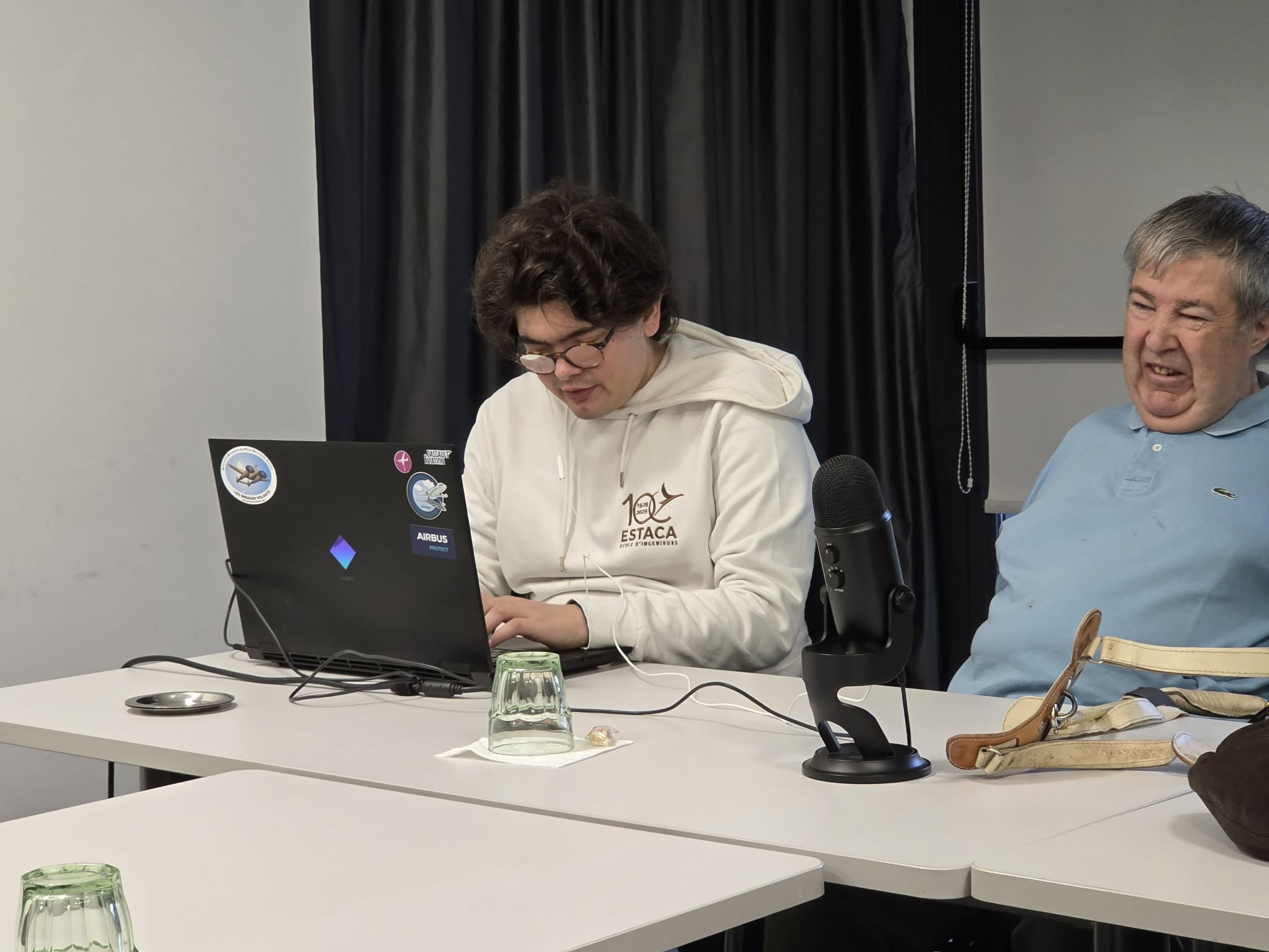 Des visages souriants autour de Quentin à son ordinateur lords de l'AG.