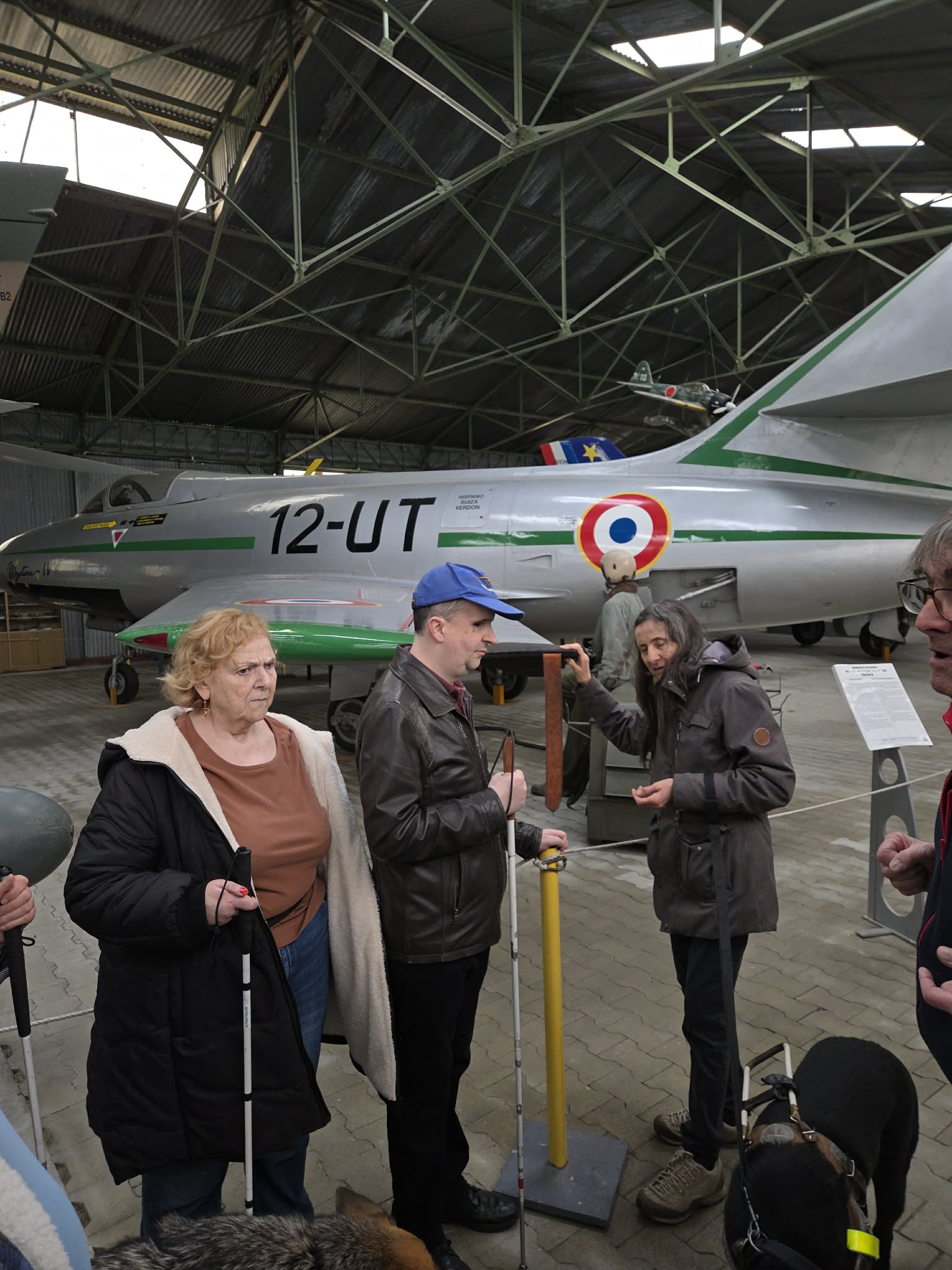 Cathy, Thomas et Isa devant un avion, à l'intérieur du Musée, en train de toucher des éléments.