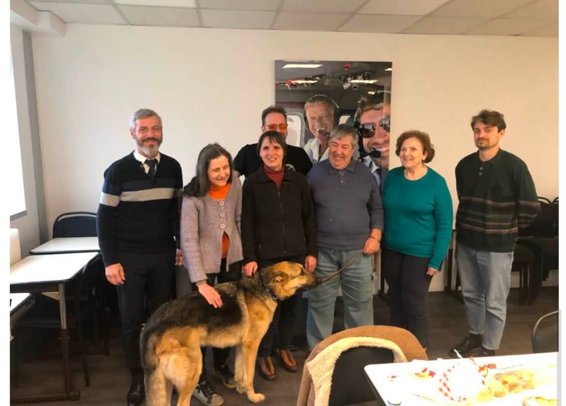 Photo de famille! Nos apprenants, tout sourire, avec leurs formateurs et un fidèle toutou, posent tous dans la salle de classe.